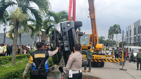 Petugas mengevakuasi mobil yang masuk got di Jalan Batununggal Indah Raya, Kecamatan Bandung Kidul, Bandung, Selasa (28/1/2025). Foto: Robby Bouceu/kumparan