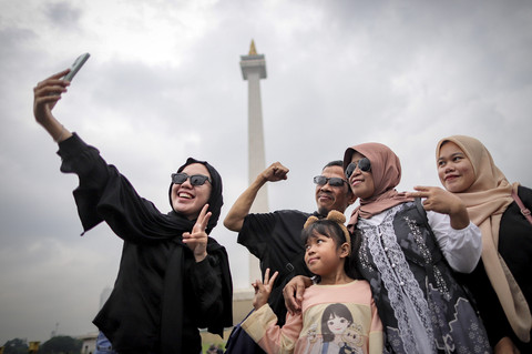 Warga berswafoto saat mengunjungi kawasan Monumen Nasional (Monas), Jakarta, Selasa (28/1/2025). Foto: Jamal Ramadhan/kumparan