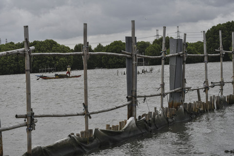 Kapal nelayan melintas di samping pagar laut di Pesisir Tarumajaya, Desa Segarajaya, Kabupaten Bekasi, Jawa Barat, Kamis (30/1/2025). Foto: Fakhri Hermansyah/ANTARA FOTO