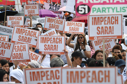 Para pengunjuk rasa memegang poster saat unjuk rasa di monumen People Power di Manila pada tanggal 31 Januari 2025, untuk mendukung pengaduan pemakzulan terhadap Wakil Presiden Filipina Sara Duterte. Foto: Ted ALJIBE / AFP