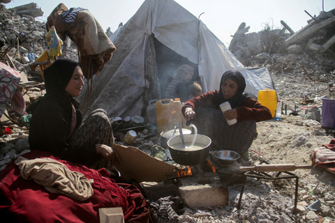 Warga Palestina memasak di dekat reruntuhan rumahanya yang hancur selama serangan Israel di kamp pengungsi Jabalia, Jalur Gaza utara, Kamis (29/1/2025). Foto: Mahmoud Issa/REUTERS