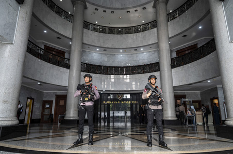Dua polisi berjaga di gedung Mahkamah Konstitusi saat melakukan pengamanan sidang pengucapan putusan sela (dismissal) sengketa Pilkada 2024 di Jakarta, Selasa (4/2/2025). Foto: Bayu Pratama S/ANTARA FOTO
