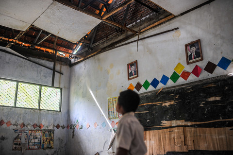 Seorang siswa melihat kondisi ruang kelas yang rusak di SD Negeri Pasirtenjo 4, Pandeglang, Banten, Selasa (4/2/2025). Foto: ANTARA FOTO/Muhammad Bagus Khoirunas