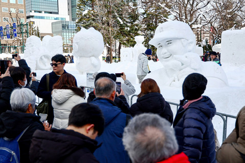 Warga memotret patung salju selama Festival Salju Sapporo di Sapporo, Prefektur Hokkaido, Jepang, Selasa (4/2/2025). Foto: JIJI PRESS / AFP