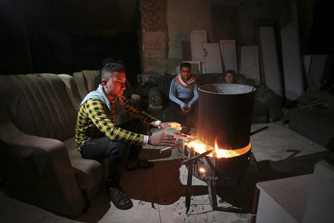 Warga Palestina duduk di sekitar api unggun untuk menghangatkan diri saat pemadaman listrik di tengah gencatan senjata antara Israel dan Hamas, di Kota Gaza, Senin (3/2/2025). Foto: Dawoud Abu Alkas/REUTERS