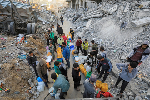 Warga Palestina mengisi wadah berisi air di kamp pengungsi Jabalia, jalur Gaza utara, Rabu (5/2/2025). Foto: Mahmoud Issa/REUTERS