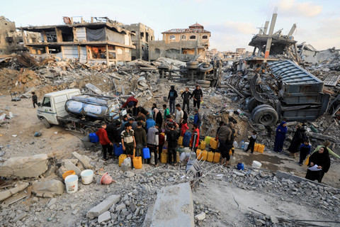 Warga Palestina mengisi wadah berisi air di kamp pengungsi Jabalia, jalur Gaza utara, Rabu (5/2/2025). Foto: Mahmoud Issa/REUTERS