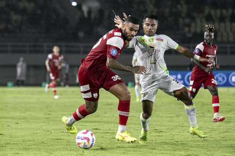 Pesepak bola Persis Solo Jhon Cley Jesus Silva (kiri) berebut bola dengan pesepak bola Persebaya Surabaya Ardi Idrus (kanan) pada pertandingan BRI Liga 1 di Stadion Manahan, Solo, Jawa Tengah, Jumat (7/2/2025). Foto: Mohammad Ayudha/ANTARA FOTO