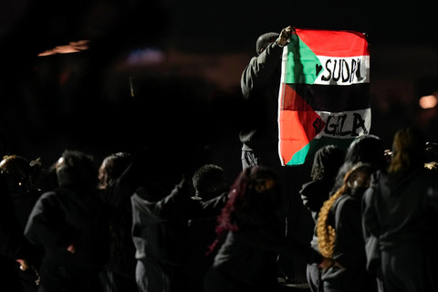 Seorang pengunjuk rasa memegang bendera Palestina bertuliskan "Gaza" dan "Sudan" saat rapper AS Kendrick Lamar tampil pada  Super Bowl Halftime Show di New Orleans, Louisiana, AS, Minggu (9/2/2025). Foto: Frank Franklin II/AP Photo