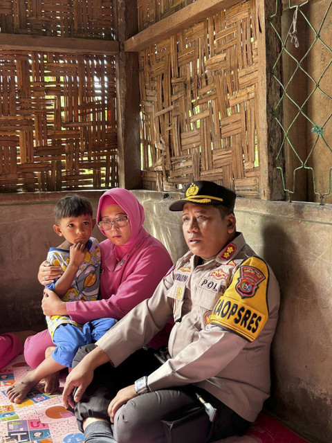 Kapolres Manggarai Timur AKBP Suryanto saat memberikan bantuan ke rumah Marta, tersangka pembunuhan terhadap suaminya. Foto: Dok. Istimewa