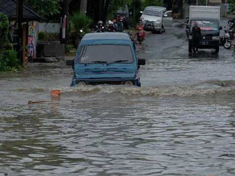 Sebuah mobil nekat melintas banjir di Jalan Gunung Salak, Kota Denpasar, Bali, Rabu (12/2). Foto: Denita BR Matondang/kumparan