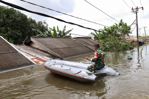Seorang anggota Babinsa menaiki perahu untuk melihat kondisi banjir di Perumnas Antang, Makassar, Sulawesi Selatan, Rabu (12/2/2025). Foto: Arnas Padda/ANTARA FOTO