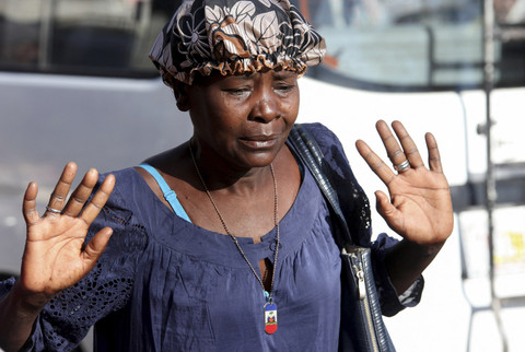 Seorang wanita bereaksi setelah putranya ditembak mati oleh penyerang tak dikenal, di Port-au-Prince, Haiti, Rabu (12/2/2025). Foto: Fildor PQ Egeder/REUTERS