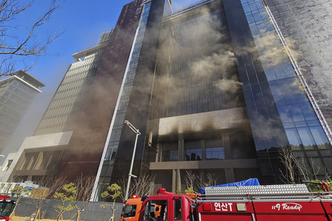 Petugas pemadam kebakaran memadamkan api di proyek pembangunan Hotel Mewah di Busan, Korea Selatan, Jumat (14/2/2025). Foto: Yonhap/AFP
