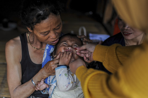 Bidan Puskesmas Cisimeut Rika Nopita memberikan vitamin A kepada anak Suku Badui di Kampung Cisadane, Lebak, Banten, Minggu (16/2/2025). Foto: Muhammad Bagus Khoirunas/ANTARA FOTO