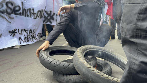 Massa aksi dari Universitas Nasional langsung membakar ban sesampainya di Patung Kuda, Jakarta pada Kamis (20/2/2025). Foto: Abid Raihan/kumparan