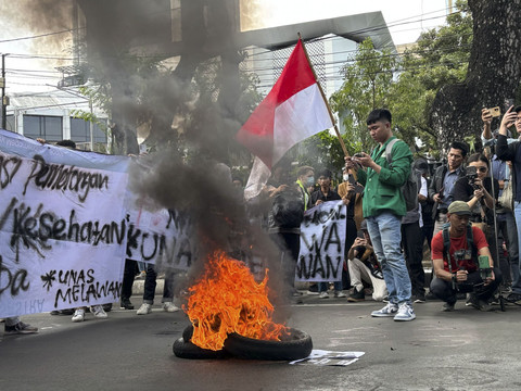Massa aksi dari Universitas Nasional langsung membakar ban sesampainya di Patung Kuda, Jakarta pada Kamis (20/2/2025). Foto: Abid Raihan/kumparan