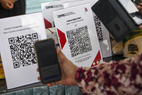 Pengunjung memindai kode pembayaran digital saat sosialisasi penggunaan QRIS Kantor Perwakilan Bank Indonesia Kepulauan Riau (KPw BI Kepri) pada gelaran pasar murah di Batam, Kepulauan Riau, Jumat (21/2/2025). Foto: ANTARA FOTO/Teguh Prihatna