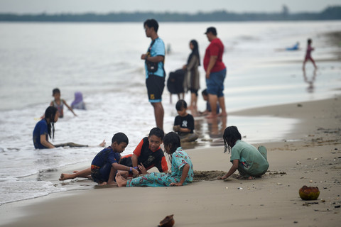 Sejumlah pengunjung bermain pasir di tepi Pantai Panrita Lopi, Muara Badak, Kutai Kartanegara, Kalimantan Timur, Minggu (23/2/2025). Foto: M Risyal Hidayat/ANTARA FOTO