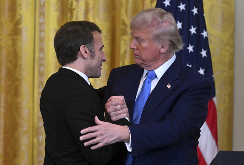 Presiden Amerika Serikat Donald Trump berjabat tangan dengan Presiden Prancis Emmanuel Macron saat pertemuan delegasi Amerika Serikat dengan Prancis di Gedung Putih, Amerika Serikat, Senin (24/2/2025). Foto: Roberto SCHMIDT/AFP