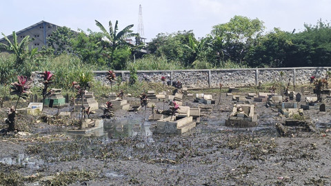 Sejumlah orang tetap menjalankan tradisi nadran atau ziarah kubur jelang bulan Suci Ramadan di TPU di Bojongsoang, Kabupaten Bandung, yang sempat terendam banjir imbas tanggul Sungai Cipundung jebol.  Foto: Robby Bouceu/kumparan