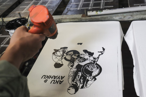 Rico Lubis saat menyablon kaos. Foto: Darryl Ramadhan/kumparan