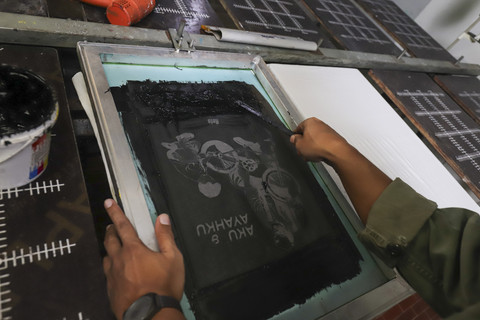 Rico Lubis saat menyablon kaos. Foto: Darryl Ramadhan/kumparan