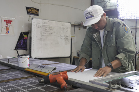 Rico Lubis saat menyablon kaos. Foto: Darryl Ramadhan/kumparan