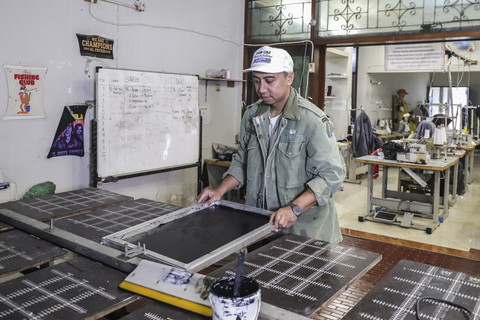 Rico Lubis saat menyablon kaos. Foto: Darryl Ramadhan/kumparan