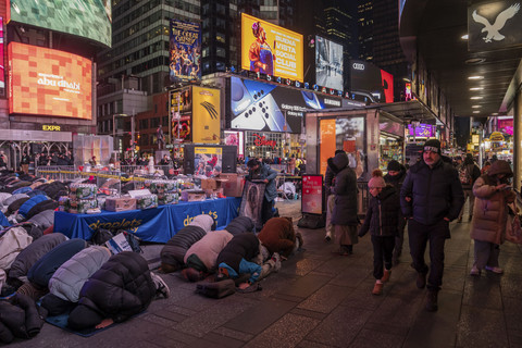 Sejumlah umat Muslim berkumpul untuk beribadah salat Tarawih selama bulan Ramadan di Times Square, New York City, Senin (3/3/2025) WIB. Foto: ADAM GRAY/AFP