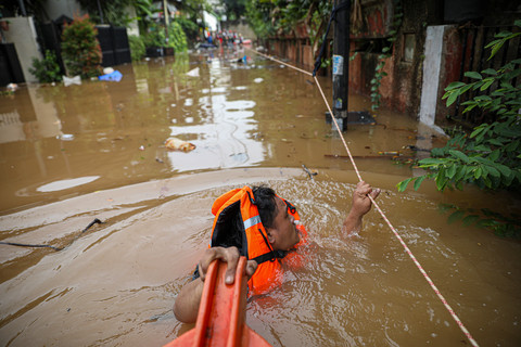 Warga melewati banjir yang merendam di kawasan perumahan IKPN Jakarta Selatan, Selasa (4/3/2025). Foto: Aditia Noviansyah/kumparan