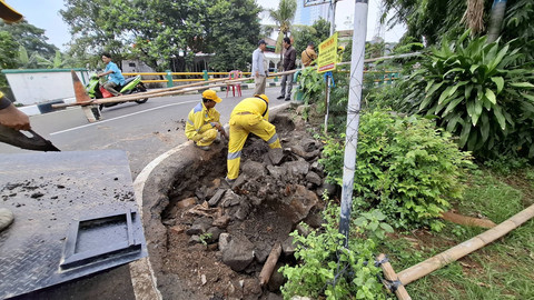 Petugas Dinas Bina Marga Jakarta Selatan melakuan perbaikan turap sisi jalan jembatan penghubung Bintaro-Pondok Pinang yang longsor akibat arus dari kali Pesanggrahan di Jalan Haji Muhi, Jakarta Selatan, Selasa (4/3/2025). Foto: Aditia Noviansyah/kumparan
