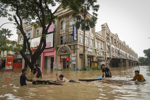 Warga melintas saat banjir di Grand Galaxy City, Kota Bekasi, Jawa Barat, Selasa (4/3/2025). Foto: Iqbal Firdaus/kumparan