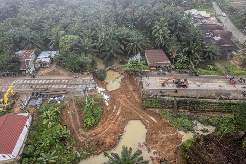 Foto udara warga menyaksikan kondisi jalan lintas Sumatera yang amblas di Desa Sirih Sekapur, Bungo, Jambi, Rabu (5/3/2025). Foto: ANTARA FOTO/Wahdi Septiawan
