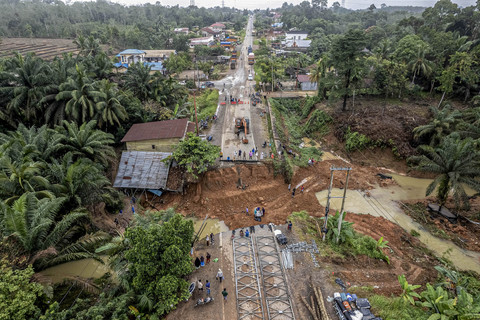 Foto udara warga menyaksikan kondisi jalan lintas Sumatera yang amblas di Desa Sirih Sekapur, Bungo, Jambi, Rabu (5/3/2025). Foto: ANTARA FOTO/Wahdi Septiawan
