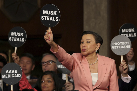Anggota DPR AS Nydia Velazquez (D-NY) memegang tanda protes bersama rekan-rekannya dari Partai Demokrat saat Presiden AS Donald Trump berpidato di sesi gabungan Kongres di U.S. Capitol Washington, DC, Selasa (4/3/2025). Foto: Win McNamee/Pool/REUTERS