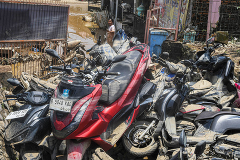 Warga mengamati mobil dan motor yang terdampak banjir luapan Kali Bekasi di Sekolah Permata Sakti di Perumahan Pondok Gede Permai (PGP), Jatirasa, Bekasi, Jawa Barat, Rabu (5/3/2025). Foto: ANTARA FOTO/Fakhri Hermansyah