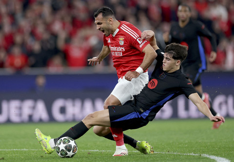 Pemain Barcelona Pau Cubarsi menjatuhkan pemain Benfica Vangelis Pavlidis pada pertandingan leg pertama Liga Champions Eropa di Stadion da Luz, Lisbon, Portugal, Rabu (5/3/2025). Foto: Filipe Amorim/AFP