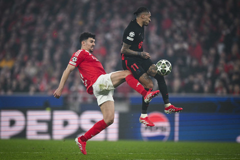 Pemain Benfica Tomas Araujo berebut bola dengan pemain Barcelona Rapinha pada pertandingan leg pertama Liga Champions Eropa di Stadion da Luz, Lisbon, Portugal, Rabu (5/3/2025). Foto: Patricia De Melo Moreira/AFP