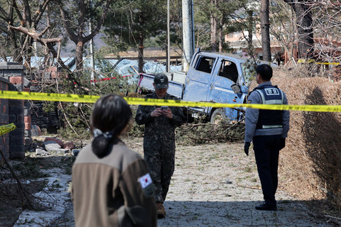 Militer Korea Selatan dan Polisi berjaga di dekat mobil dan bangunan rusak setelah sebuah bom MK-82 jatuh di sebuah desa di Pocheon, Korea Selatan, Kamis (6/3/2025). Foto: YONHAP / AFP