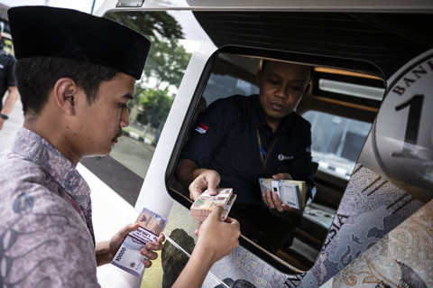 Seorang warga (kiri) menukarkan uang rupiah baru melalui layanan mobil kas keliling Bank Indonesia (BI) di halaman Masjid Agung Jawa Tengah (MAJT), Semarang, Jawa Tengah, Jumat (7/3/2025). Foto: Aprillio Akbar/ANTARA FOTO