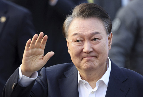 Presiden Korea Selatan Yoon Suk-yeol melambaikan tangan saat pembebasan dirinya setelah Pengadilan Korea Selatan menyatakan bebas di Uiwang, Korea Selatan, Kamis (8/2/2025).  Foto: Kim Hong-Ji/Reuters