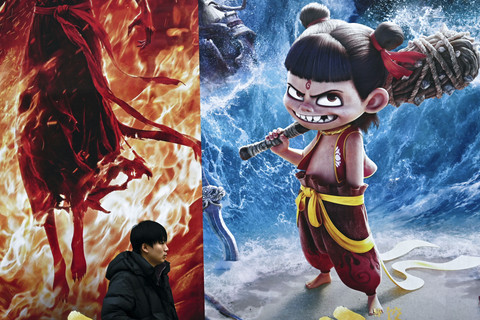 Seorang pria berjalan melewati sebuah promosi untuk film animasi Tiongkok Ne Zha 2, yang diproduksi oleh Enlight Media, di luar kantor pusat perusahaan produksi tersebut di Beijing, Cihna (11/2/2025). Foto: Pedro Pardo/AFP