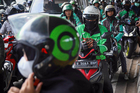Pengemudi ojek online (ojol) menunggu datangnya penumpang di Halte LRT Pancoran, Jakarta, Rabu (12/3/2025). Foto: Iqbal Firdaus/kumparan