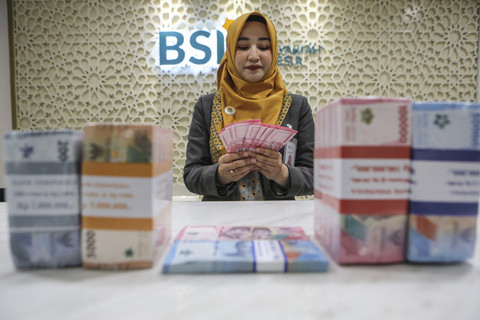 Karyawan menunjukan uang pecahan seratus ribu di BSI Kantor Cabang The Tower, Jakarta, Kamis (13/3/2025). Foto: Asprilla Dwi Adha/ANTARA FOTO