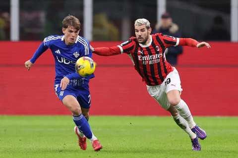 Pemain AC Milan Theo Hernandez berebut bola dengan pemain Como Nico Paz pada pertandingan Liga Italia di San Siro, Milan, Italia, Sabtu (15/3/2025). Foto: Claudia Greco/REUTERS
