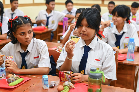 Sejumlah siswa menyantap menu makanan bergizi gratis (MBG) yang dibagikan di SMP Negeri 1 Denpasar, Bali, Senin (17/3/2025).  Foto: Fikri Yusuf/ANTARA FOTO