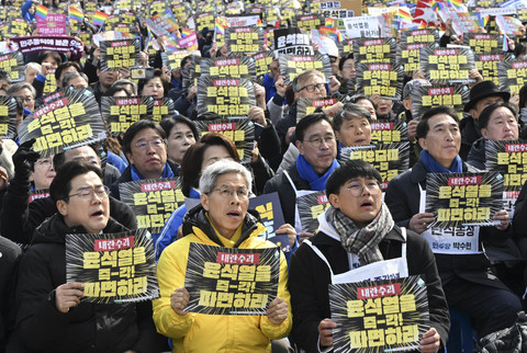Para pengunjuk rasa memegang plakat bertuliskan "Singkirkan Yoon Suk Yeol segera!" saat mereka berbaris menuju Mahkamah Konstitusi dalam demonstrasi menentang pemakzulan Presiden Korea Selatan Yoon Suk Yeol di Seoul, Senin (17/3/2025). Foto: Jung Yeon-je/AFP