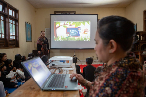 Guru Pasraman yang ada di Desa Ngadiwono, Tosari, Pasuruan, Jawa Timur, sedang mengajar menggunakan media laptop dan proyektor yang baru saja didapat dari pemberian hibah NeutraDC melalui program CSR, Two Hands Hub NeutraDC. Foto: Dok. Telkom