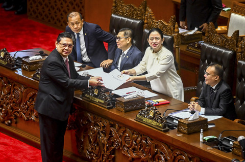 Ketua Komisi I DPR Utut Adianto (kiri) menyerahkan laporan kepada Ketua DPR Puan Maharani pada Rapat Paripurna ke-15 DPR Masa Persidangan II Tahun Sidang 2024-2025 di Kompleks Parlemen, Senayan, Jakarta, Kamis (20/3/2025). Foto: Rivan Awal Lingga/ANTARA FOTO